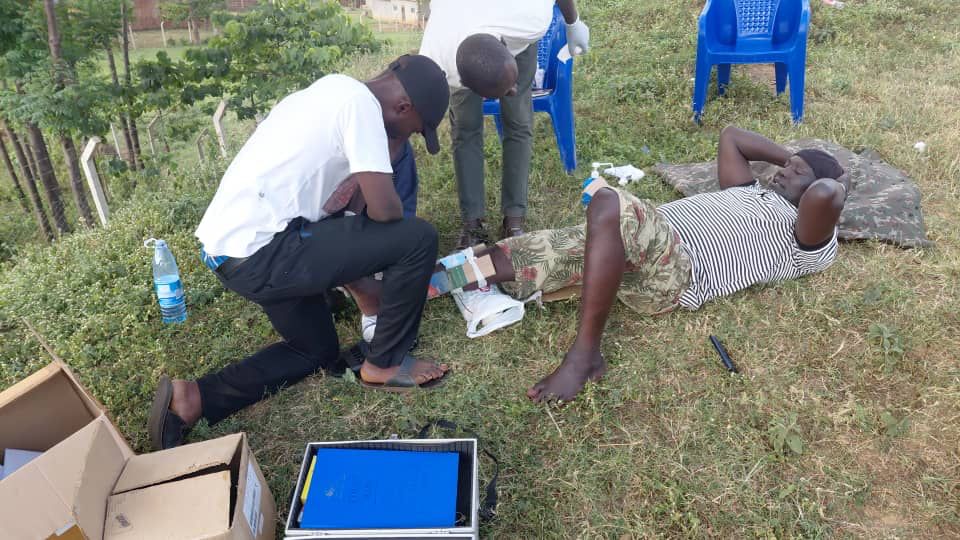 Security team member applying a splint and dressing to a colleague's leg during first aid training