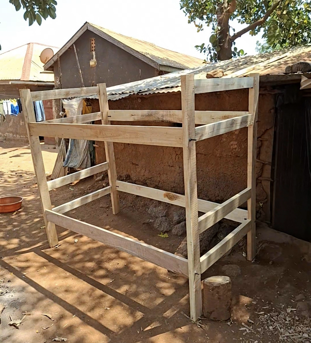 A hand-built wooden bunk bed frame made by Ndegge in his yard in Mawero, Busia