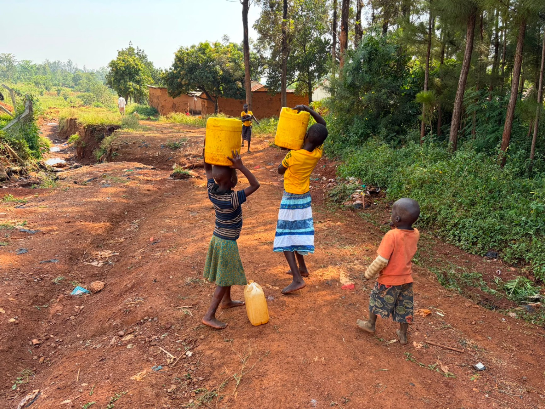 Children of Mawero carrying jerrycans of water before the well was built