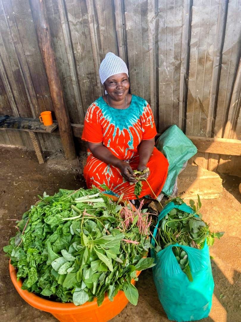 The site cook in Busia preparing a large basin of fresh greens for the team