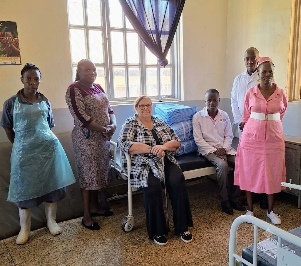 A nurse arranges a mosquito net over a mother and newborn in the Busia Health Centre IV maternity ward