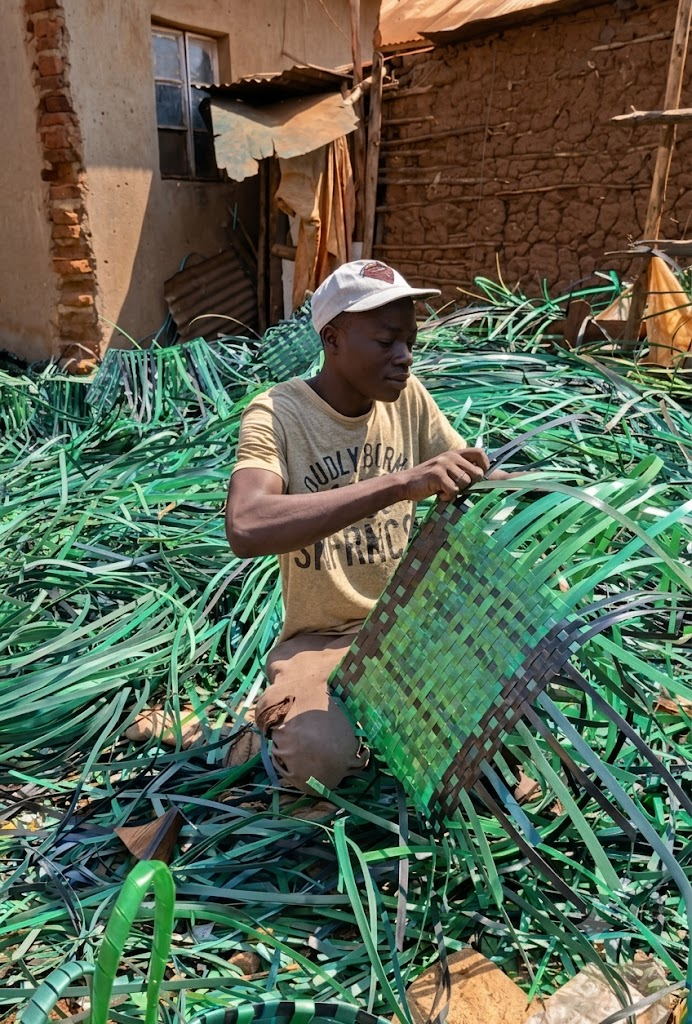 A younger Mawero weaver hand-weaving a green basket